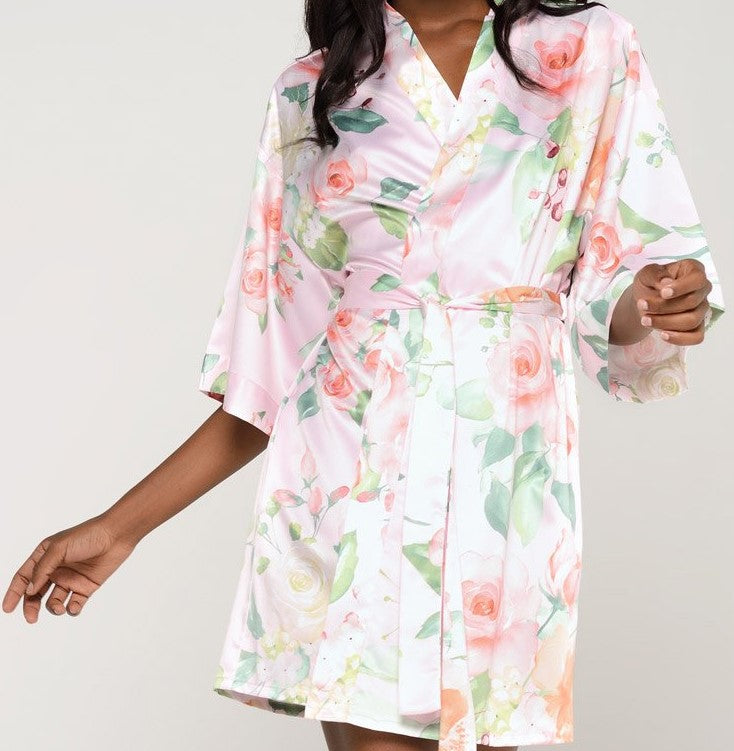 With varying shades of pinks and oranges on a soft pink background, style is always in bloom with this premium satin robe. The feminine pattern has a series of roses in soft pastels repeating throughout the garment for a beautiful chic piece. Wear it as a stylish cover or on the big day when you prepare for your wedding. It’s a beautiful gift that any bride-to-be or bridesmaid will appreciate. Customize it for a gift that she’ll be sure to treasure.