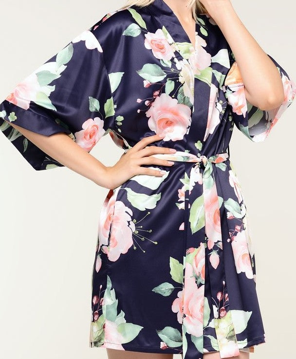 With varying shades of pinks and oranges on an elegant navy background, style is always in bloom with this premium satin robe. The feminine pattern has a series of roses in soft pastels repeating throughout the garment for a beautiful chic piece. Wear it as a stylish cover or on the big day when you prepare for your wedding. It’s a beautiful gift that any bride-to-be or bridesmaid will appreciate. Customize it for a gift that she’ll be sure to treasure.